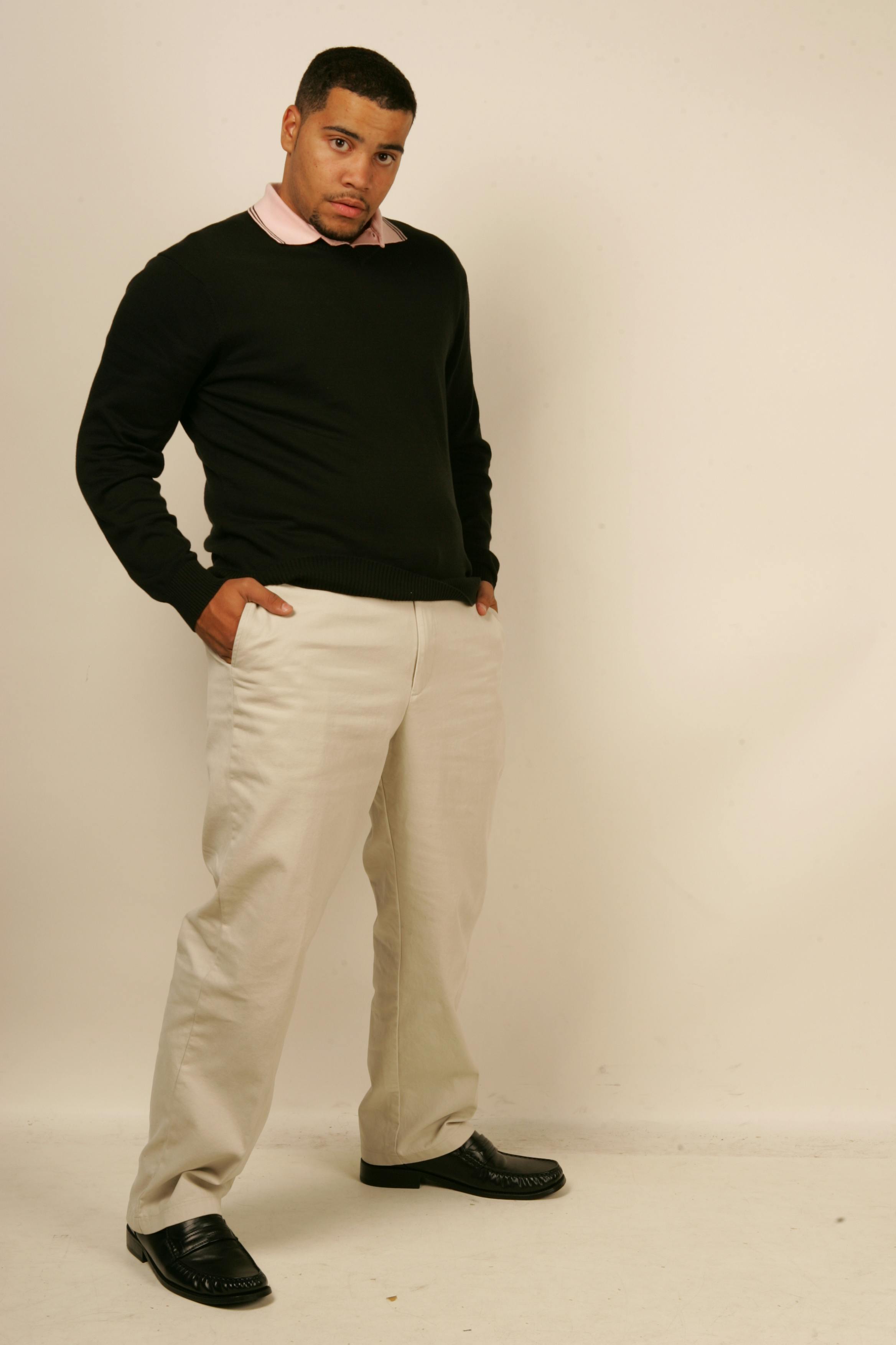 wearing black short-sleeved t-shirt and beige pants